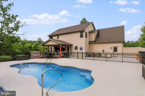 a view of a house with swimming pool and sitting area