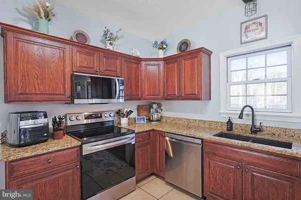 a kitchen with stainless steel appliances granite countertop a sink dishwasher stove and cabinets