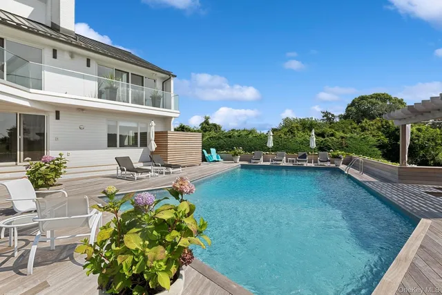 a living room with furniture a flat screen tv and a floor to ceiling window