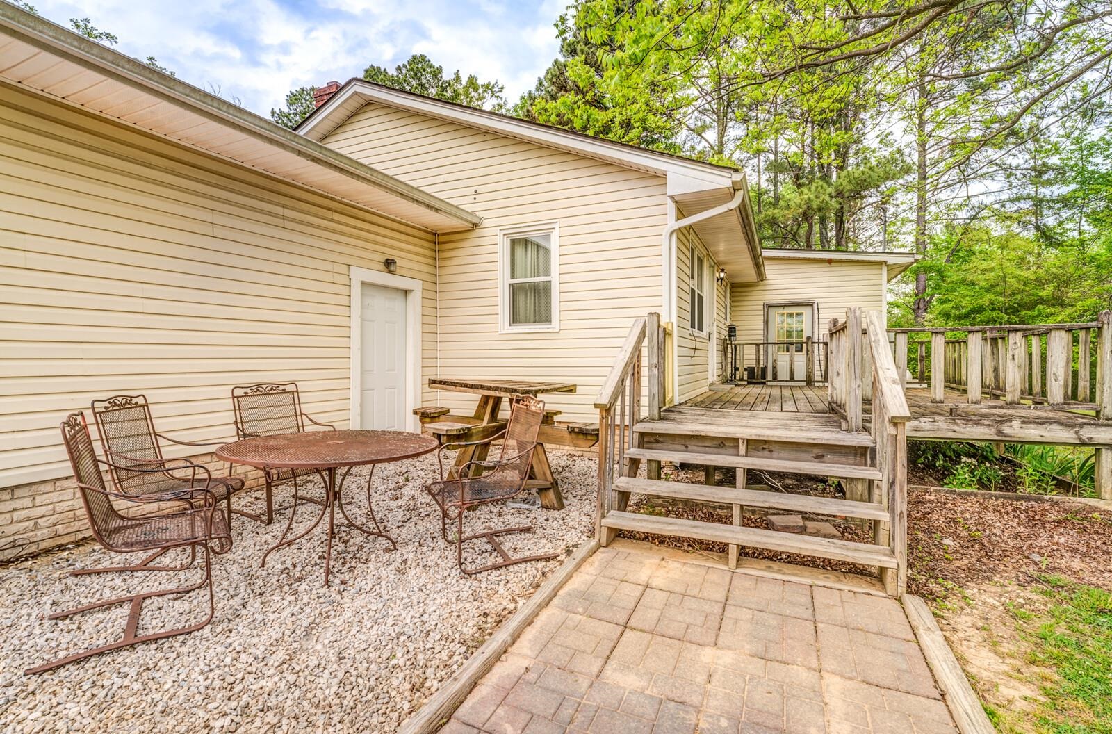 6125 Warren Road Oakland, TN 38060 - Photo 37 of 40 Exterior rear featuring beige siding, multiple entry points, a wooden deck with railing, and a stone paver pathway