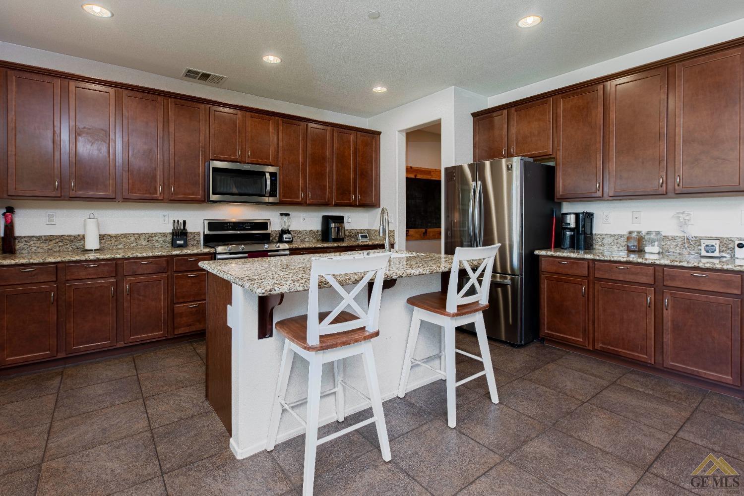 Undisclosed Address Bakersfield, CA 93314 - Photo 14 of 49 a kitchen with stainless steel appliances granite countertop a stove a sink dishwasher a refrigerator and a microwave