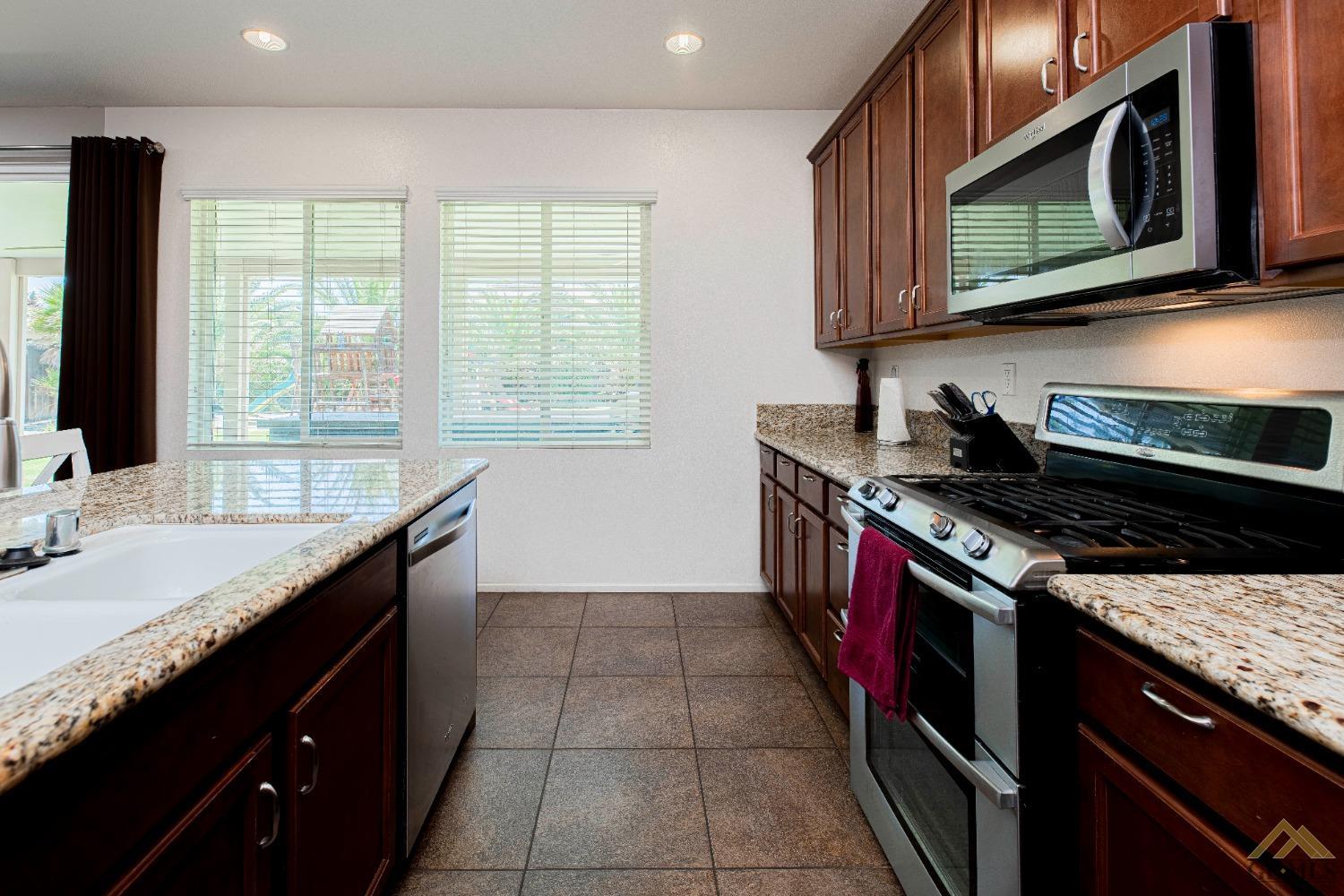 Undisclosed Address Bakersfield, CA 93314 - Photo 16 of 49 a kitchen with a stove sink and microwave