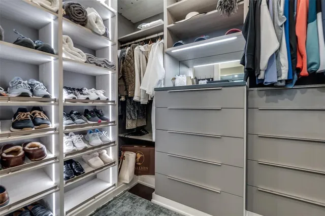 a view of walk in closet with clothes and shoes