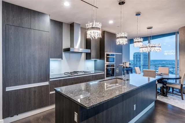 a kitchen with stainless steel appliances granite countertop a sink a counter space and wooden floor