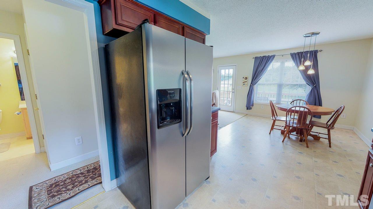 1130 Willie Gray Road Timberlake, NC 27583 - Photo 8 of 27 a view of a hallway with furniture and a refrigerator