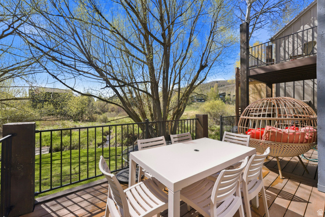 7935 Mustang Loop Road Park City, UT 84098 - Photo 5 of 60 Spacious outdoor deck with wood-finish flooring, black metal railing, and a serene green landscape
