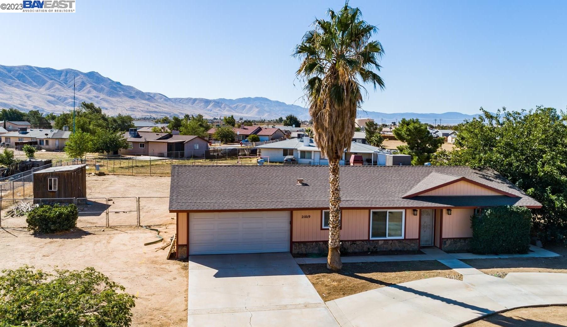 a front view of a house with a yard and mountain view