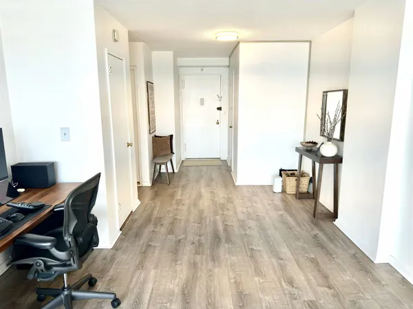 a view of a hallway with wooden floor and furniture