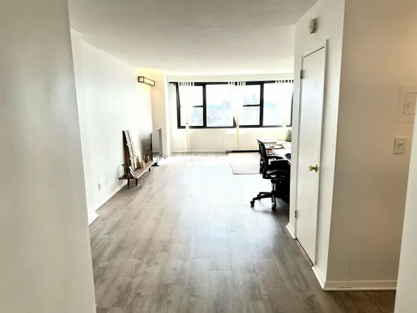 a view of a room with wooden floor and furniture
