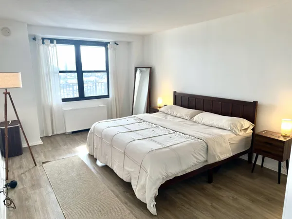 a bedroom with a bed table and a window