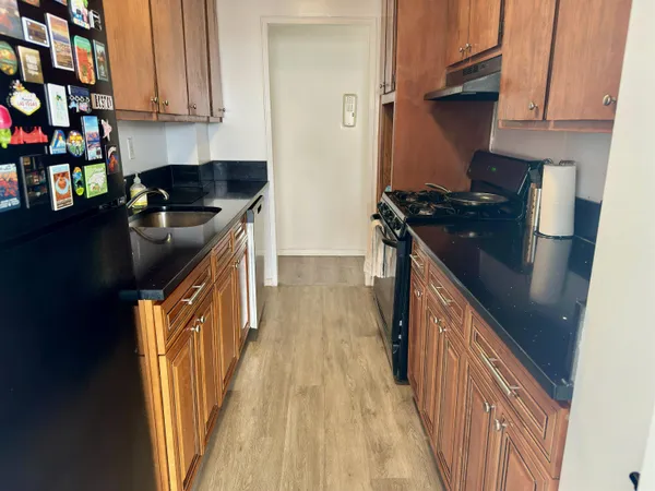 a kitchen with granite countertop a sink a stove and refrigerator