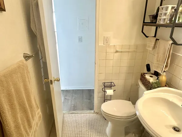 a white toilet sitting next to a bathroom sink and a shower
