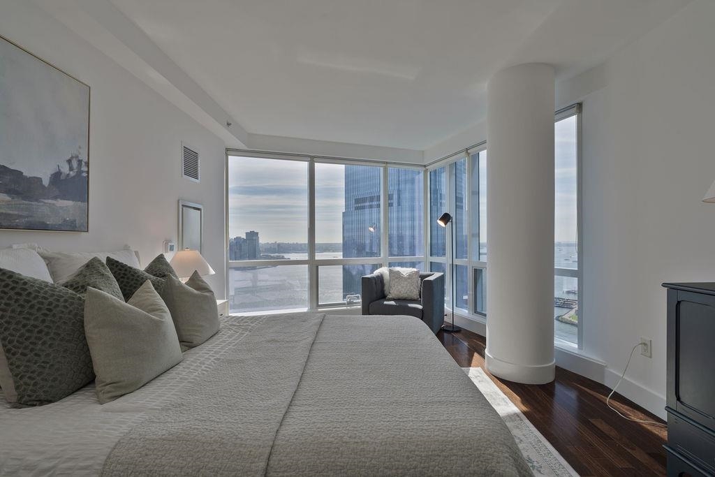 77 Hudson Street, Unit PH 4505 Jersey City, NJ 07302 - Photo 11 of 37 a living room with furniture and a large window