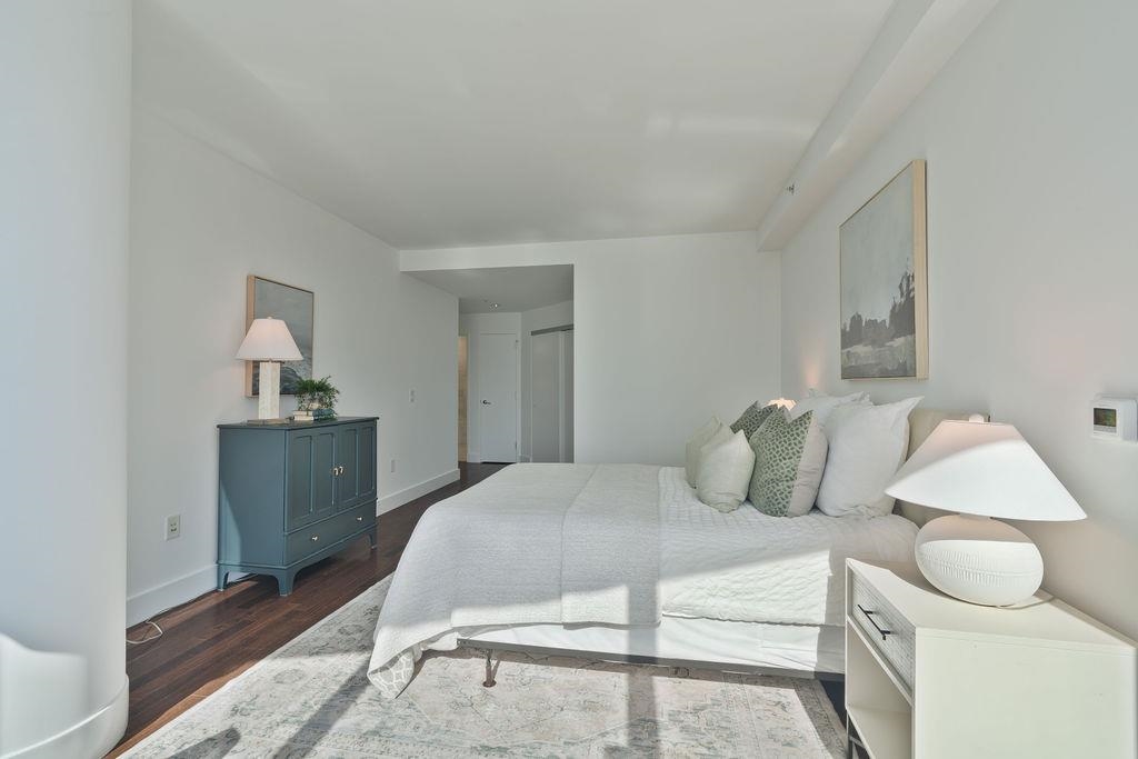 77 Hudson Street, Unit PH 4505 Jersey City, NJ 07302 - Photo 12 of 37 a bedroom with a bed and wooden floor