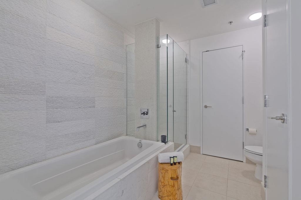 77 Hudson Street, Unit PH 4505 Jersey City, NJ 07302 - Photo 15 of 37 a bathroom with a sink a toilet and shower