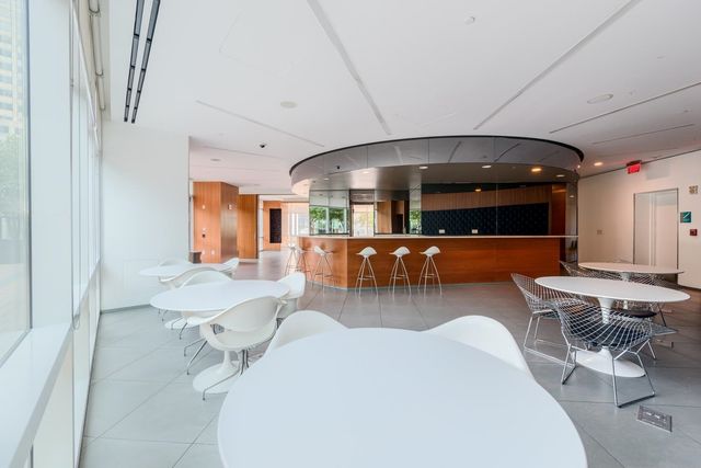 a lobby with furniture and a large mirror with potted plants