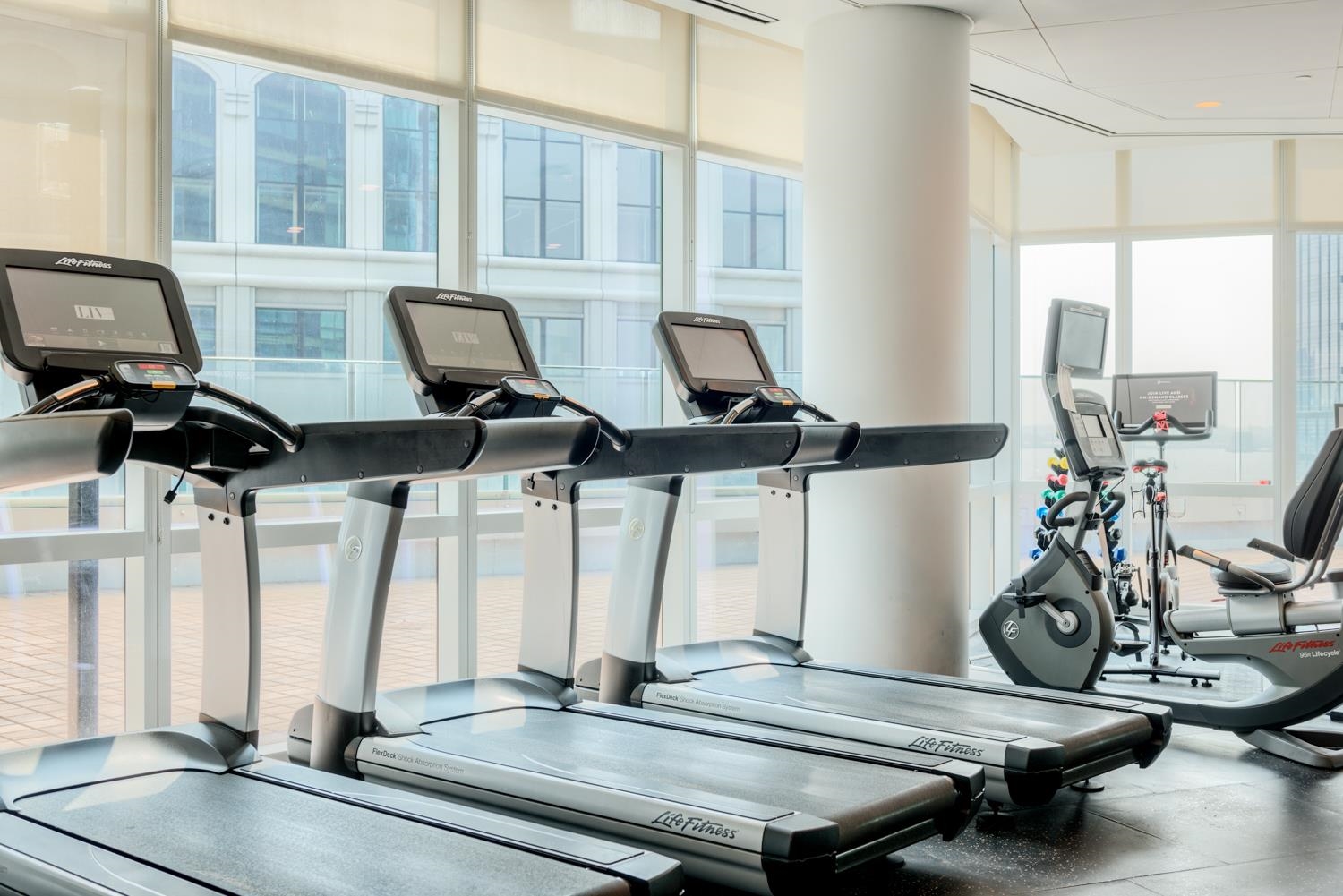 77 Hudson Street, Unit PH 4505 Jersey City, NJ 07302 - Photo 27 of 37 a room with gym equipment and large mirror