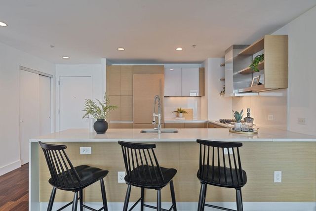a kitchen with stainless steel appliances kitchen island a table and chairs in it