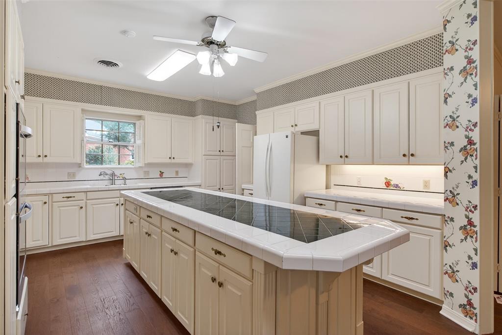 522 Rives Place Shreveport, LA 71106 - Photo 8 of 40 a kitchen with granite countertop a sink stainless steel appliances white cabinets and wooden floor