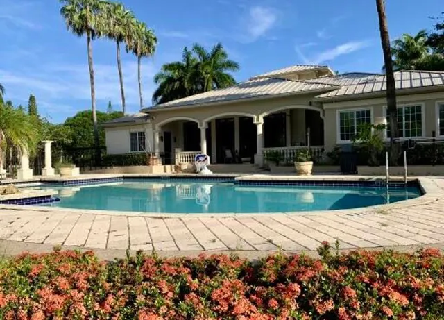 a view of the house with palm trees