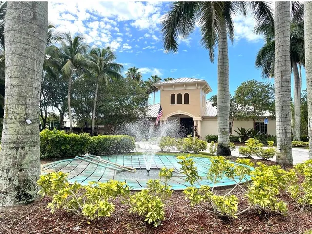 a front view of a house with a yard and potted plants