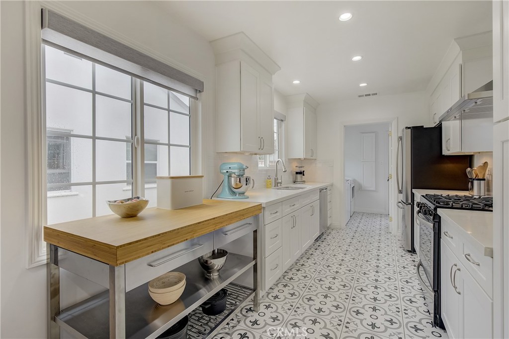 3743 North Studebaker Road Long Beach, CA 90808 - Photo 11 of 32 a kitchen that has a sink a stove and a table in it