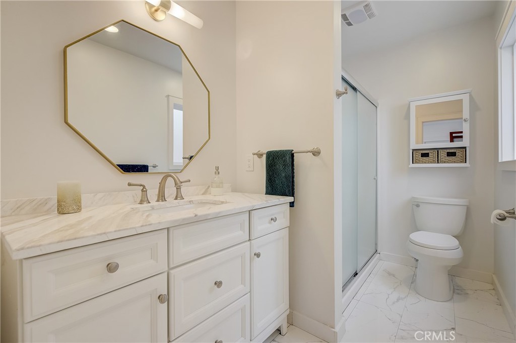 3743 North Studebaker Road Long Beach, CA 90808 - Photo 20 of 32 a bathroom with a toilet a sink and mirror