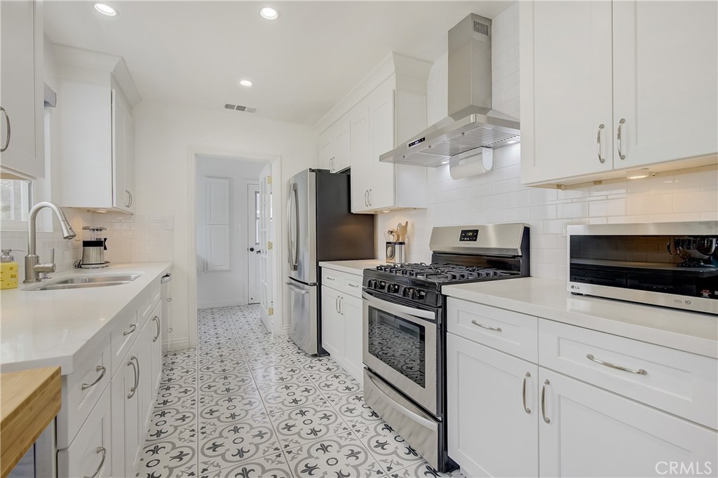 3743 North Studebaker Road Long Beach, CA 90808 - Photo 8 of 32 a kitchen with stainless steel appliances a stove a sink and a refrigerator