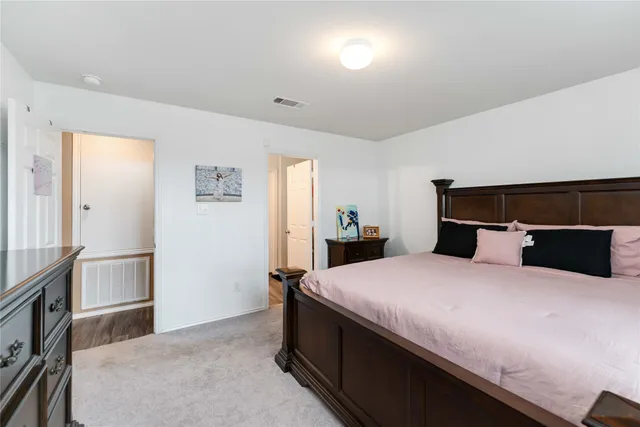 a bedroom with a bed and a refrigerator