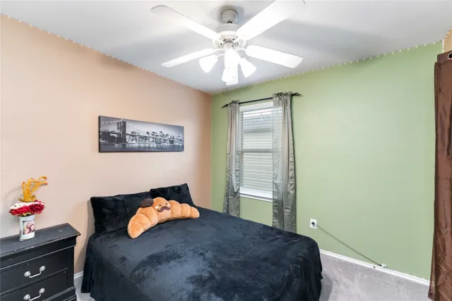 a bedroom with a bed and a chandelier fan