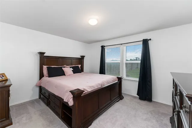 a bed sitting in a bedroom next to a window