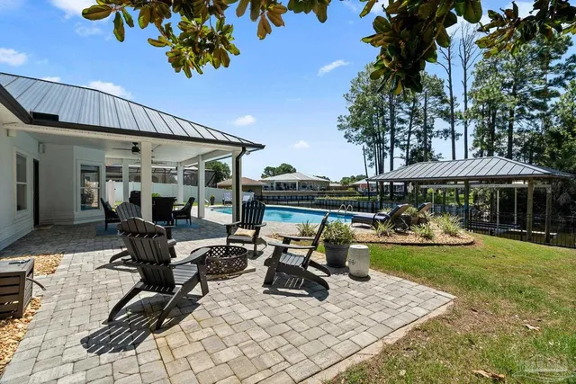 a swimming pool with barbeque oven and outdoor seating