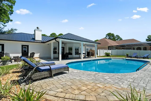 a view of swimming pool with seating area and garden