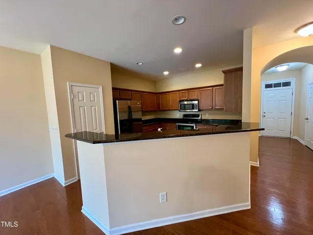 a view of kitchen with stainless steel appliances granite countertop cabinets and wooden floor
