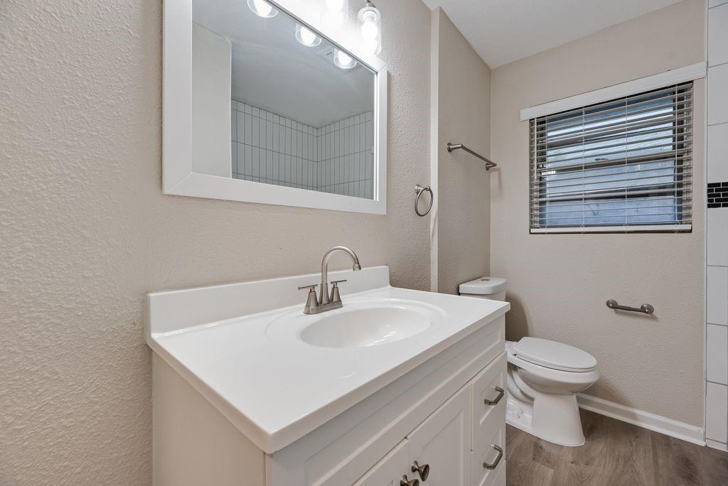 5706 Rocky Ridge Road Dallas, TX 75241 - Photo 17 of 31 a bathroom with a sink toilet and mirror
