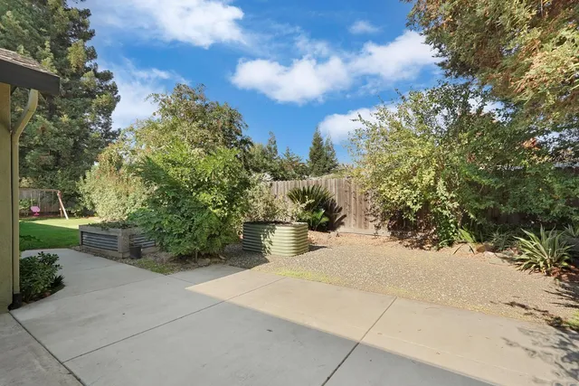 a view of a backyard with table and chairs and floor to ceiling window