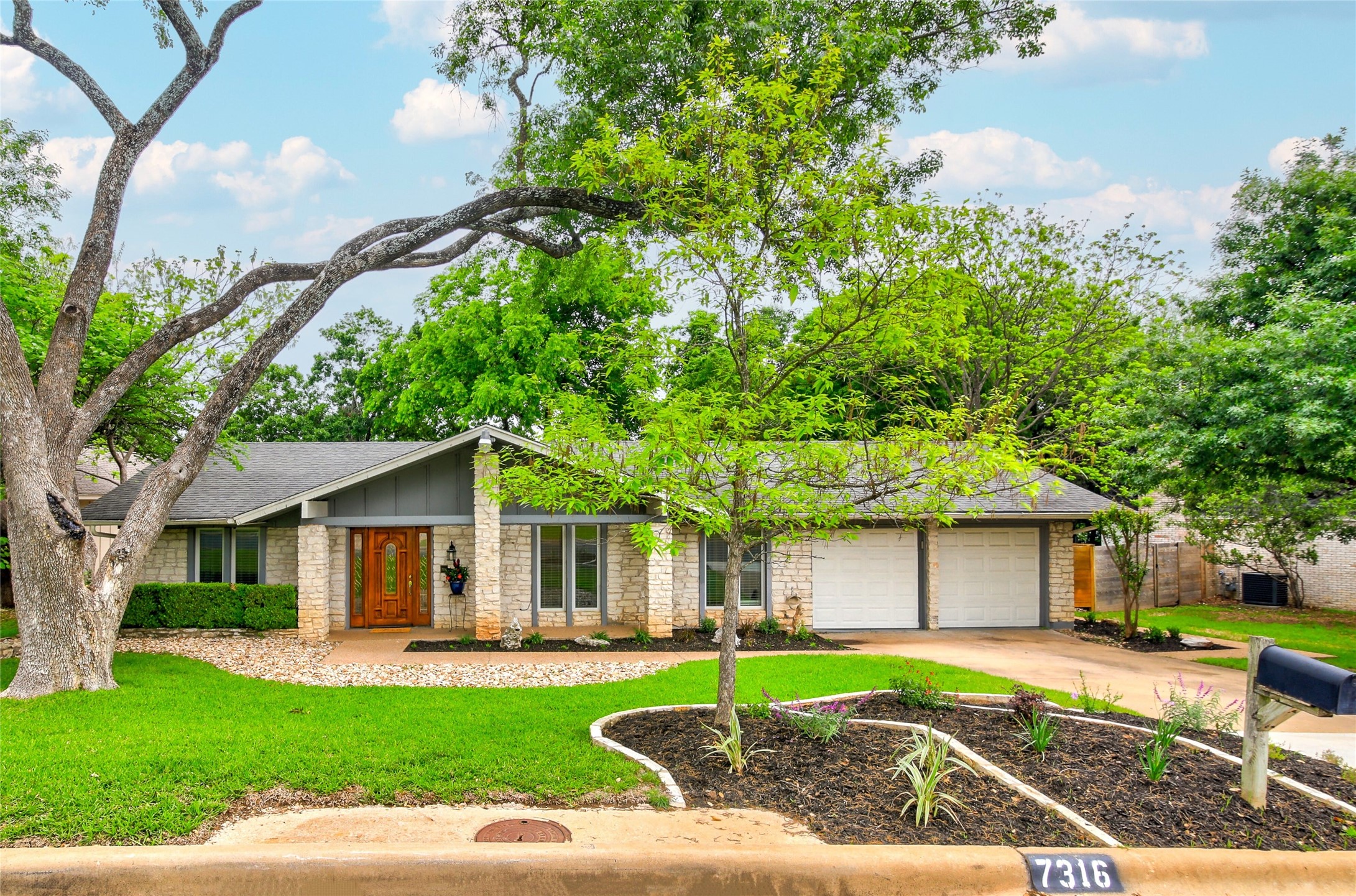 7316 Running Rope Austin, TX 78731 - Photo 1 of 1 a front view of a house with a yard and trees