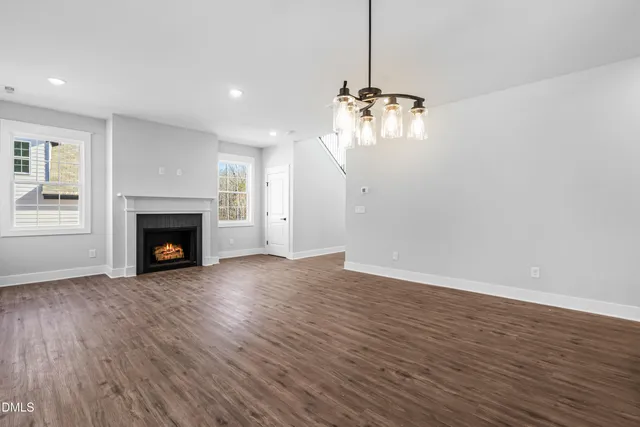 a view of a room with wooden floor and a chandelier