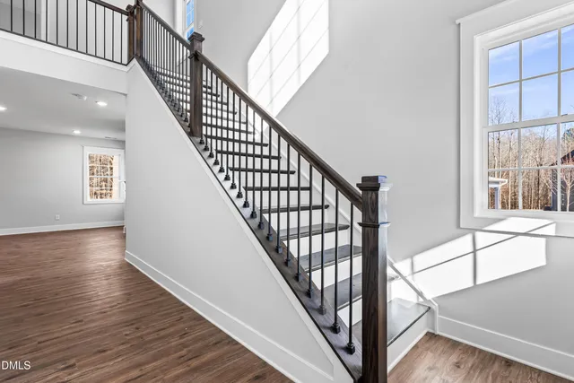 a view of staircase with wooden floor and white walls