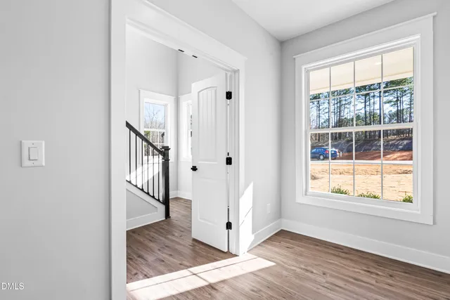 a view of a hallway with wooden floor and staircase