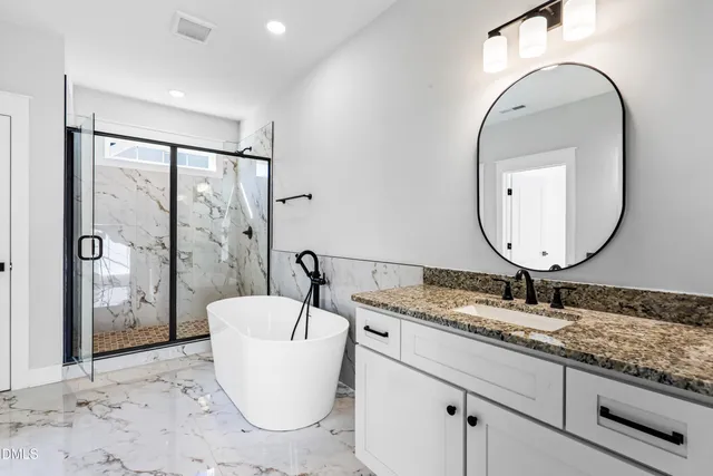 a bathroom with a granite countertop sink mirror and bathtub
