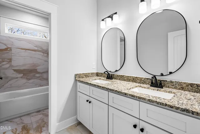 a bathroom with a granite countertop double vanity sinks and a mirror
