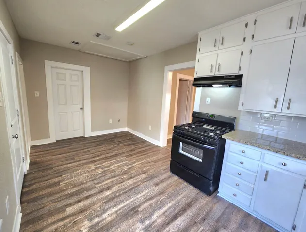 a kitchen with granite countertop a stove and a sink
