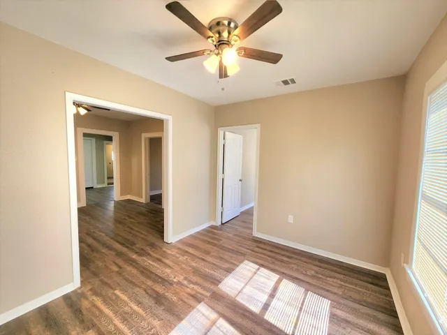 a view of an empty room and window and a kitchen