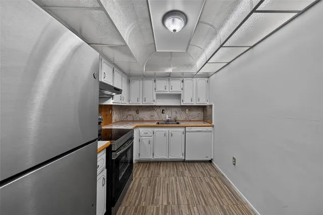 a kitchen with wooden floors and stainless steel appliances