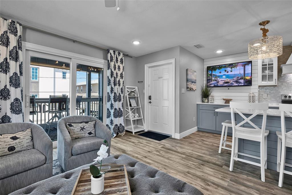 812 Gulf Boulevard, Unit 3 Indian Rocks Beach, FL 33785 - Photo 14 of 62 a living room with furniture a large window and a flat screen tv