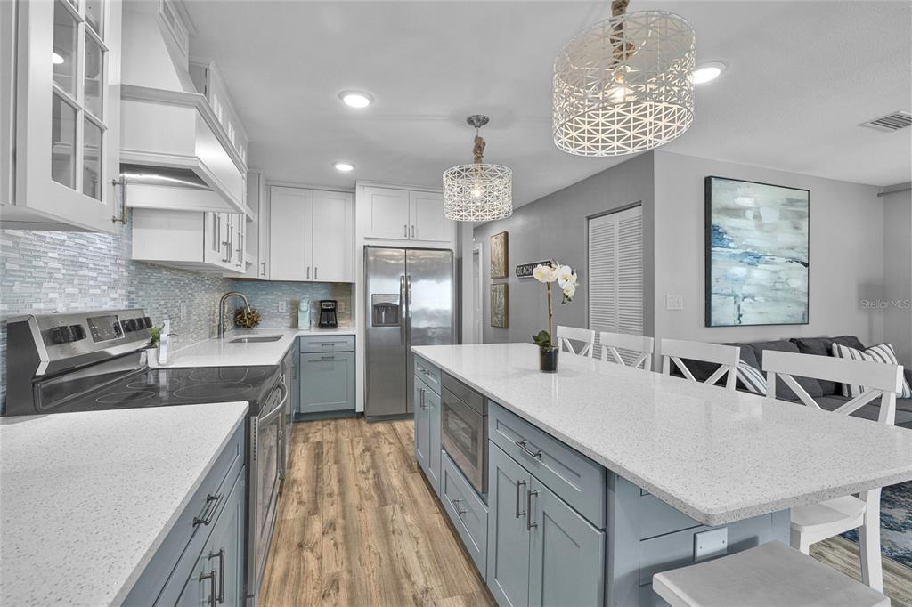 812 Gulf Boulevard, Unit 3 Indian Rocks Beach, FL 33785 - Photo 8 of 62 a large kitchen with kitchen island a large counter space a sink appliances and cabinets