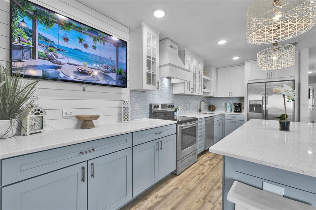 812 Gulf Boulevard, Unit 3 Indian Rocks Beach, FL 33785 - Photo 10 of 62 a kitchen with stainless steel appliances double vanity sink and wooden floor