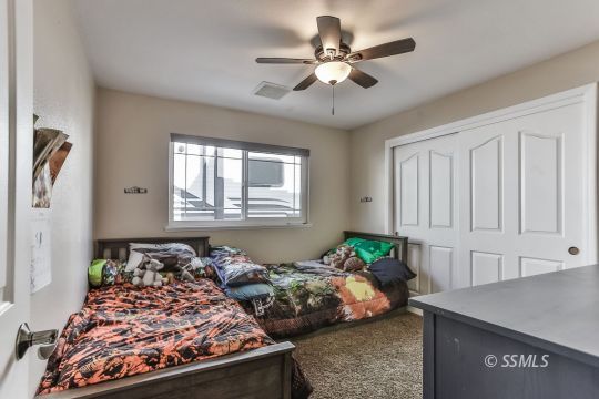 1220 Jennifer Court Ridgecrest, CA 93555 - Photo 16 of 34 a bed room with a bed and a chandelier