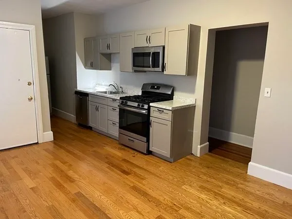 a kitchen with a stove top oven and refrigerator
